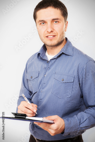 Photo: Casual businessman holding a clipboard Casual businessman holding a clipboard