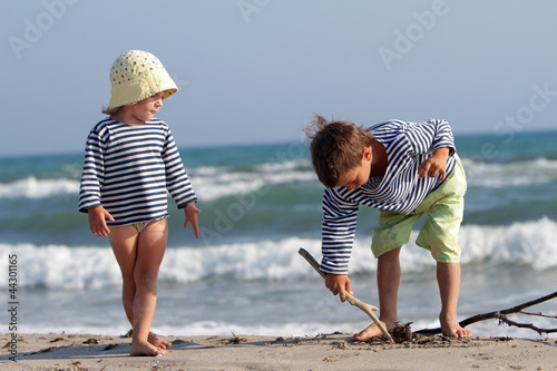 Photo: two happy children playing on beach two happy children playing on beach