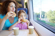 Photo: Mother and daughter eat and drink, sitting in armchair at table Mother and daughter eat and drink, sitting in armchair at table
