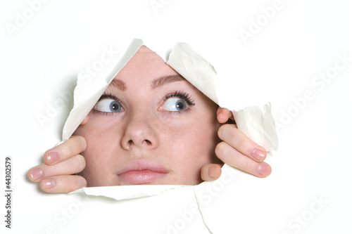 Photo: young girl looking through hole in paper young girl looking through hole in paper