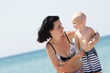 Photo: outdoor portrait of young happy mother and child on sea backgrou outdoor portrait of young happy mother and child on sea backgrou