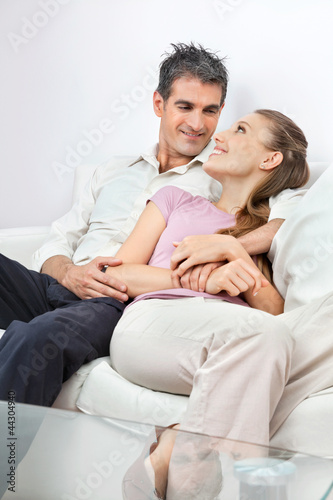Photo: Relaxed Couple Sitting On Sofa Relaxed Couple Sitting On Sofa