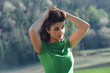 Photo: the girl with the green dress gathers her hair the girl with the green dress gathers her hair