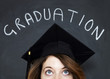 Woman in graduation gown infront of chalk board