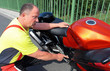Motorradfahrer erklärt technisches Detail am Motorrad