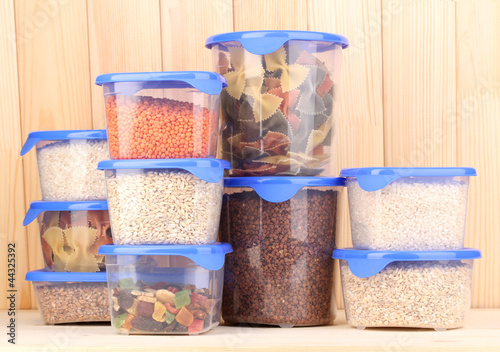 Photo: Filled plastic containers on wooden background Filled plastic containers on wooden background
