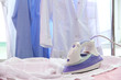 Electric iron and shirt, on cloth background