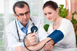 Foto: Arzt misst den Blutdruck und Puls bei Patientin Arzt misst den Blutdruck und Puls bei Patientin
