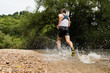 Jogger durchquert ein Bachbett