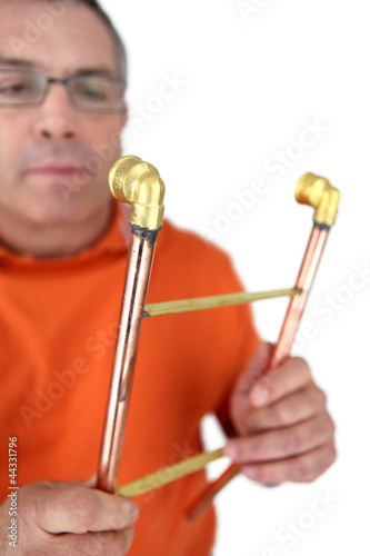 Photo: Plumber holding copper pipes Plumber holding copper pipes