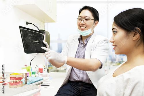 Photo: Asian dentist with x-ray and patient Asian dentist with x-ray and patient