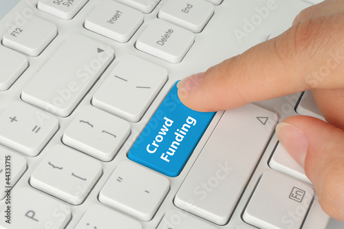 Photo: Hand pushing blue crowd funding button on keyboard Hand pushing blue crowd funding button on keyboard