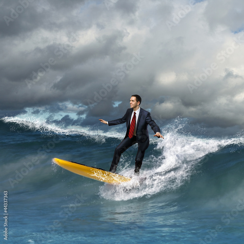 Photo: Young business person surfing on the waves Young business person surfing on the waves