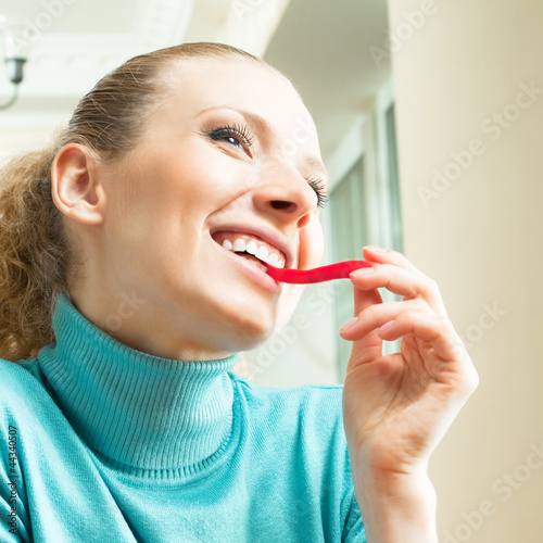 Photo: Happy smiling young woman eating salad Happy smiling young woman eating salad