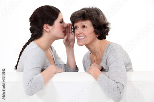 Photo: Woman telling her mother a secret Woman telling her mother a secret
