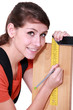 Female carpenter marking out wood with set-square