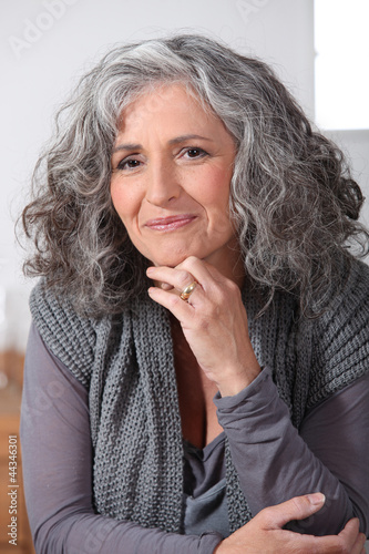 Photo: Grey-haired woman touching chin Grey-haired woman touching chin