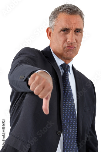 Photo: Disapproving businessman giving the thumb's down Disapproving businessman giving the thumb's down