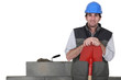 Stonemason standing proudly next to his work