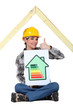 Female housebuilder with an energy rating sign
