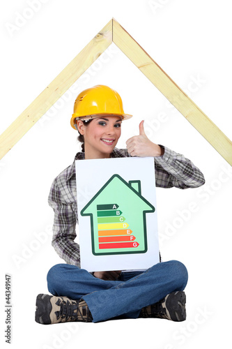 Photo: Female housebuilder with an energy rating sign Female housebuilder with an energy rating sign