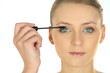 Young woman applying mascara