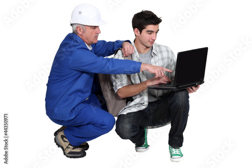 Photo: Manual worker and student with a laptop Manual worker and student with a laptop