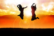 Silhouette illustration of two girls jumping happily