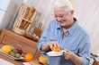 Elderly lady squeezing orange juice