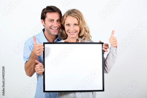 Photo: woman and man holding board woman and man holding board