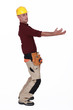 Construction worker holding something heavy