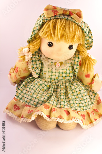Photo: Isolated sweet doll sitting at white background. Soft children t Isolated sweet doll sitting at white background. Soft children t