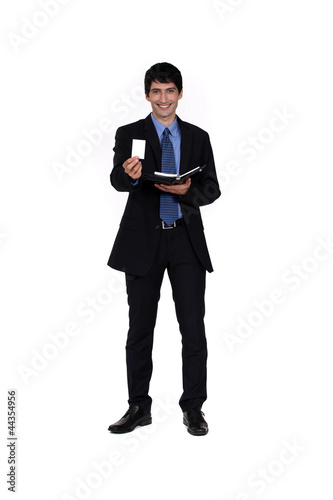 Photo: Businessman offering his card from a personal organizer Businessman offering his card from a personal organizer