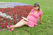 A pregnant woman (9 months) reads book in a park