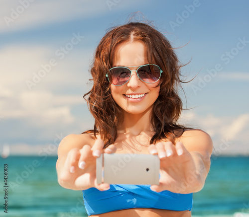 Photo: happy woman with phone on the beach happy woman with phone on the beach