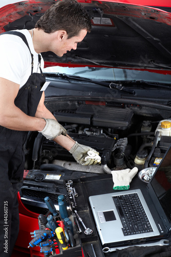Photo: Auto mechanic checking oil. Auto mechanic checking oil.