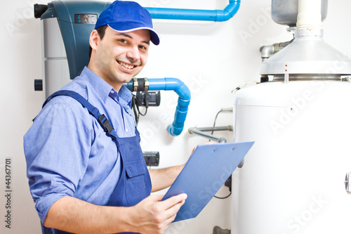 Photo: Technician servicing an hot-water heater Technician servicing an hot-water heater