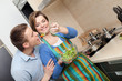 Woman feeds her husband with salad with vegetable