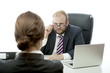 Photo: business man brunette woman at desk looking serious over glasses business man brunette woman at desk looking serious over glasses