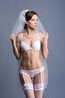 A young and sexy brunette bride in white erotic lingerie