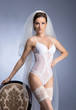 A young brunette bride posing in sexy white lingerie