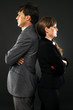 serious business couple standing back to back