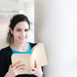 Portrait of a young woman reading a book with copy space