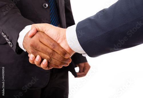 Photo: Closeup of an african and caucasian business man handshake - iso Closeup of an african and caucasian business man handshake - iso