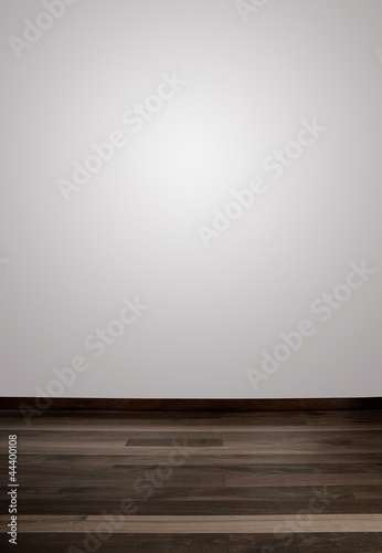Photo: Empty white wall and wooden floor with a spot lights in the wall Empty white wall and wooden floor with a spot lights in the wall