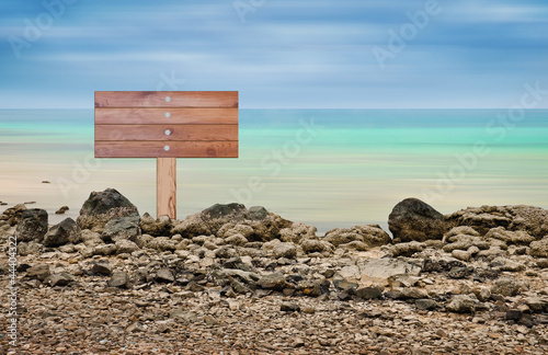 Photo: Wooden sign in seascape area Wooden sign in seascape area
