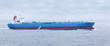 Large cargo ship with red and blue boards floats in open ocean