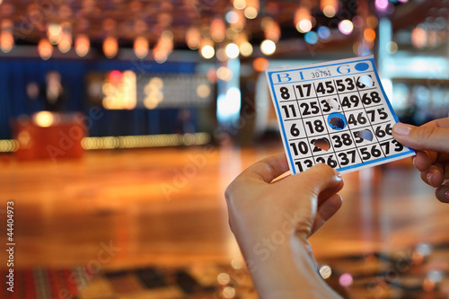 Photo: Hands hold bingo card with holes Hands hold bingo card with holes