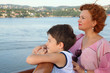 Mother and son are on board of ship and look at landscape