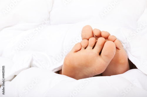 Photo: Weibliche kleine Füße unter der Bettdecke Weibliche kleine Füße unter der Bettdecke